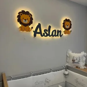 İsme özel lamba lacivert örnek isimli, yanlarında aslan figürlü lambalarla açılı yakın görünüm, ışıklar açık