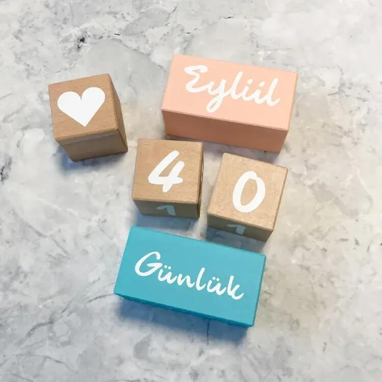 Şeftali-Ahşap-Turkuaz anı küpü seti yakından; şeftali isim bloğu, iki ahşap rakam küpü ve Günlük yazılı turkuaz blok
