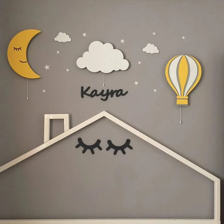Sarı aydede, bulut ve sarı uçan balon ahşap lamba, örnek isim ve ev çizgisi olan gri duvarda