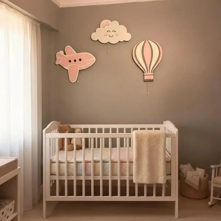 Pembe uçak, gülen yüzlü bulut ve uçan balon ahşap lamba, beyaz beşikli bebek odasının duvarında